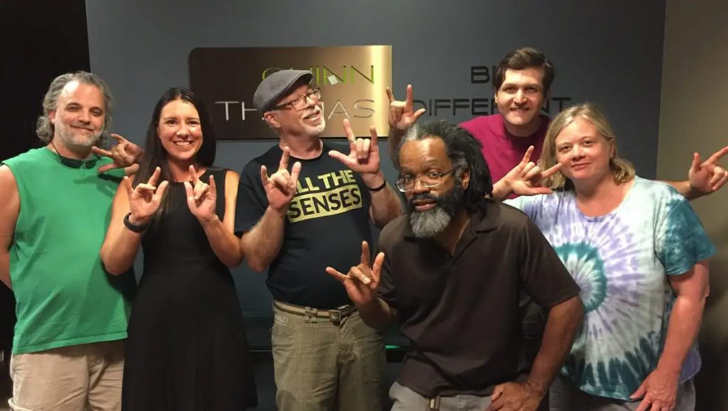 Six members of the CymaSpace team giving the "devil horns" hand sign.