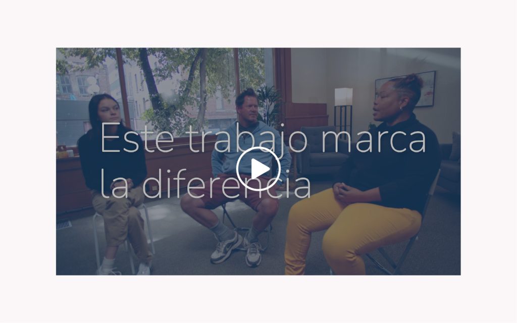 Group of people talking in a room with the words, "Este trabajo marca la diferencia" overlaid.